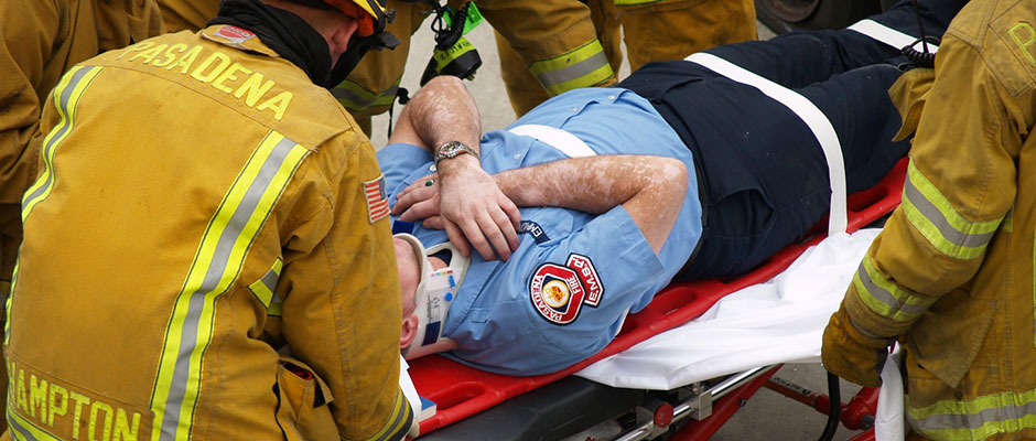 Firefighters practicing spinal immobilization on an EMS Reserve member during a drill