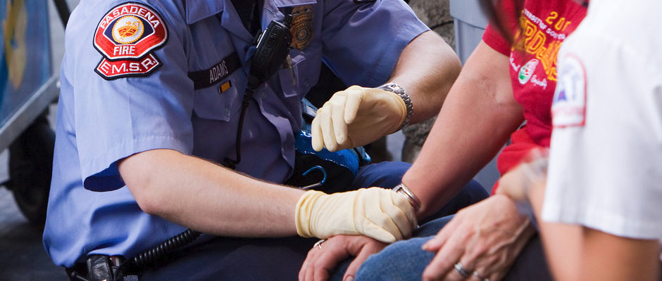 An EMS Reserve EMT treating a patient's arm at a public event