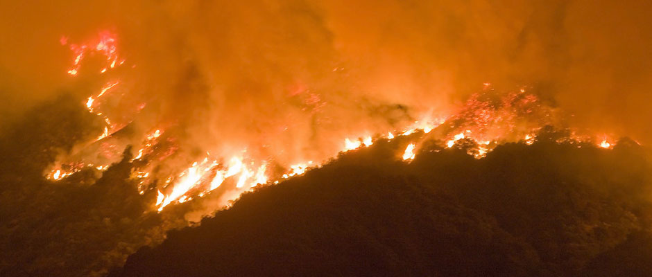 A hillside burning during a nighttime wildfire